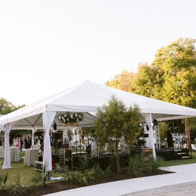 An outdoor event setup featuring a large white tent.