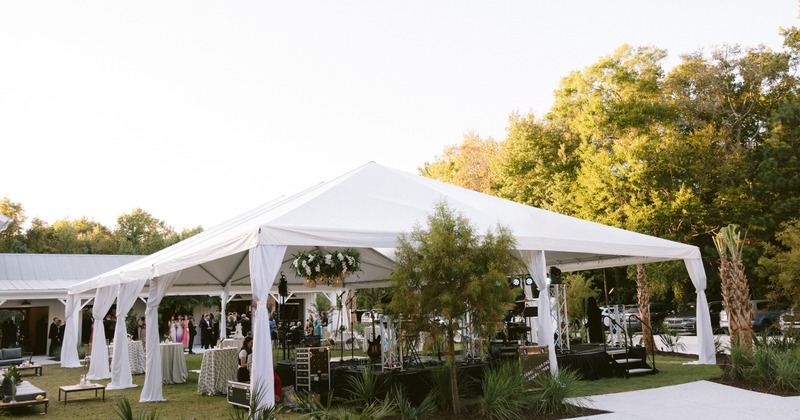 A large white frame tent set up a wedding reception