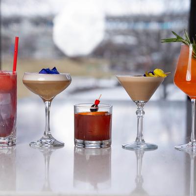 Assorted cocktails lined up on a bar counter