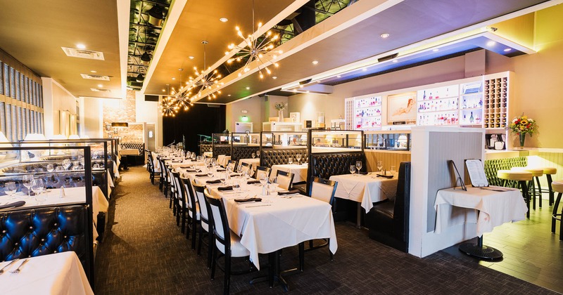 Upscale restaurant interior with elegant lighting and neatly arranged tables and chairs