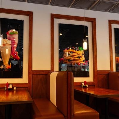 Diner booths set against a wall featuring vibrant food posters.