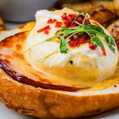 Eggs Benedict on toasted bread with microgreens.