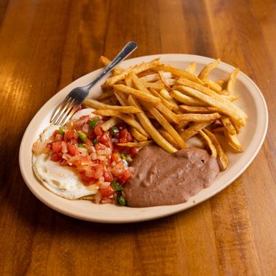 Mexican breakfast plate featuring eggs topped with fresh salsa, accompanied by beans and fries.