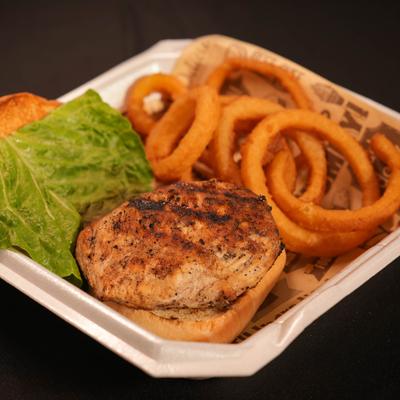 Chicken sandwich served with onion rings.