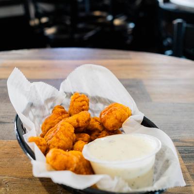Tossed boneless wings, served with a dip.