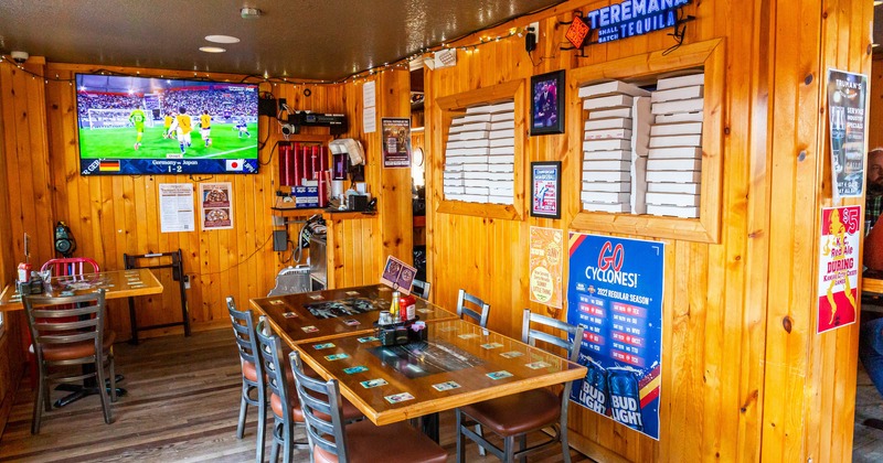 Interior, dining tables and chairs, a large wall TV screen