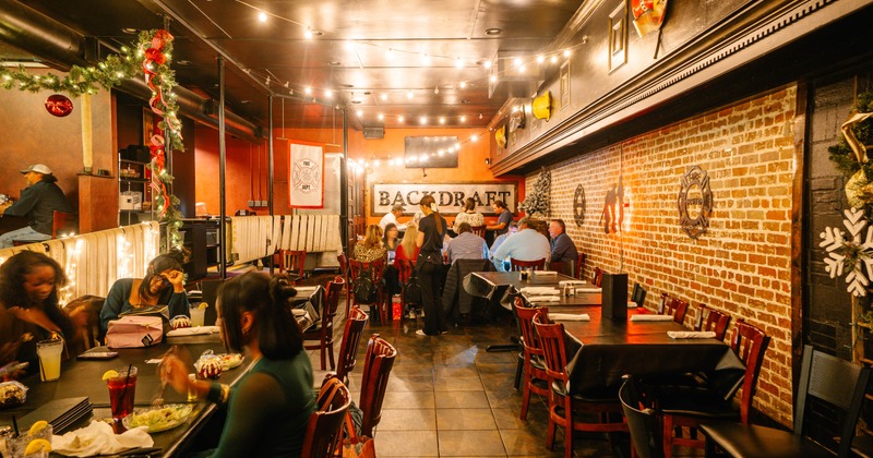 Cozy restaurant interior with warm lighting and festive decor, Groups of people are dining