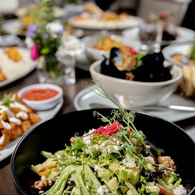Divan Salad plate displayed with other dishes behind it, close up.