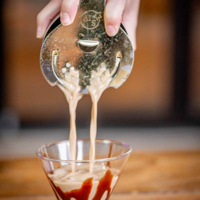 A hand pouring a drink.