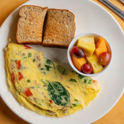 Garden Delight Omelette with bread and fresh fruit on the side.