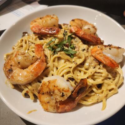 Shrimp Fettuccini Carbonara served with a golden breadstick.