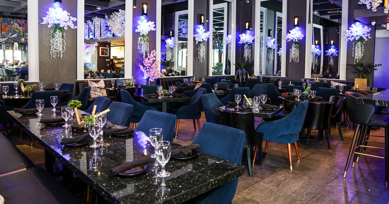 A stylish and modern restaurant interior dining area with set marble tables and upholstered chairs