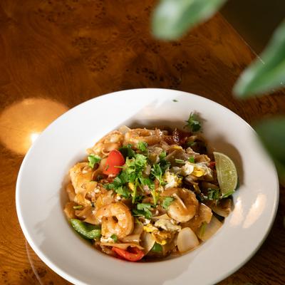 Stir fry rice noodles with  vegetables, chicken, and shrimp.