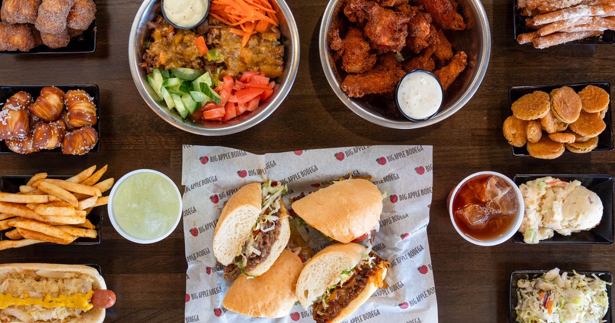 Sandwich halves served with wings, salad, and iced drinks