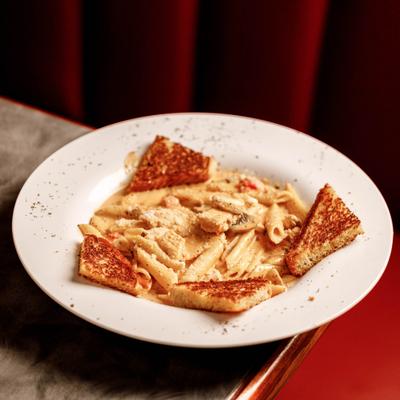 Creamy penne pasta served with toasted bread.