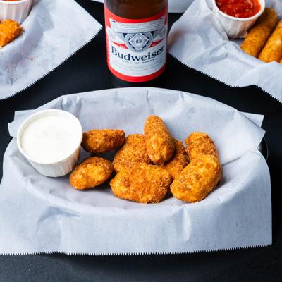 Jalapeno poppers with a cup of creamy sauce.