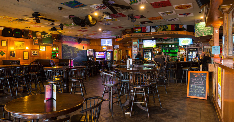 Interior, guest tables and guests sitting at the bar