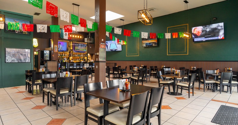 Interior, open space dining area, tables for four and two, pennant with Mexican flag colors