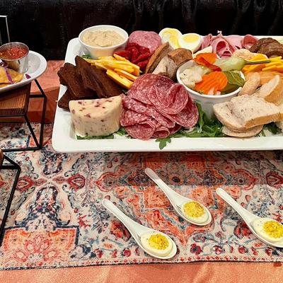 Charcuterie platter with meats, cheeses, bread, and deviled eggs.