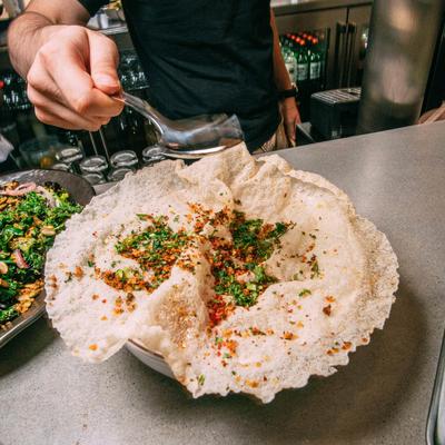 Large crisp flatbread topped with herbs and spices.