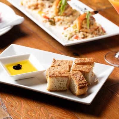 Focaccia bread served with olive oil on a white plate.