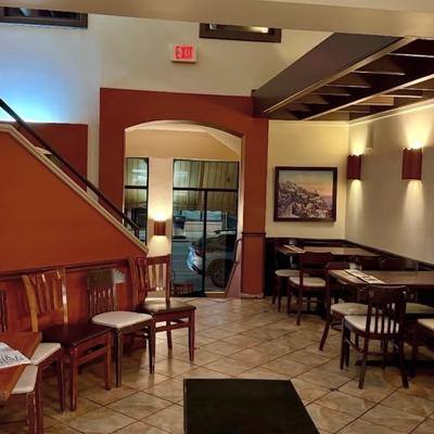 Dining area featuring tiled floors, wooden tables, and framed art.