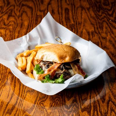 Bacon cheeseburger with mushrooms, and fries.