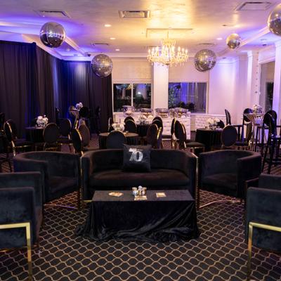 Event lounge with black seating and hanging mirror balls.