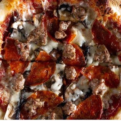 Pizza with cheese, pepperoni, sausage, and mushrooms.