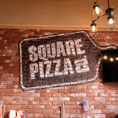 Interior, logo on exposed brick wall, American flag.