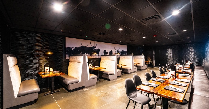 Interior of a restaurant with booth and table seating, dark ceiling