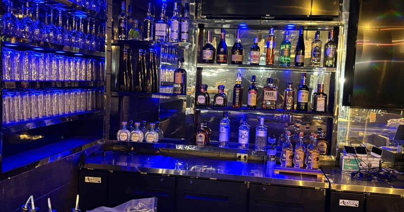 A well-stocked bar illuminated with blue lighting