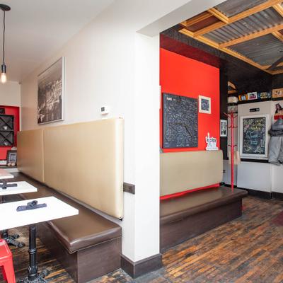 Interior seating area with tables and a bench.
