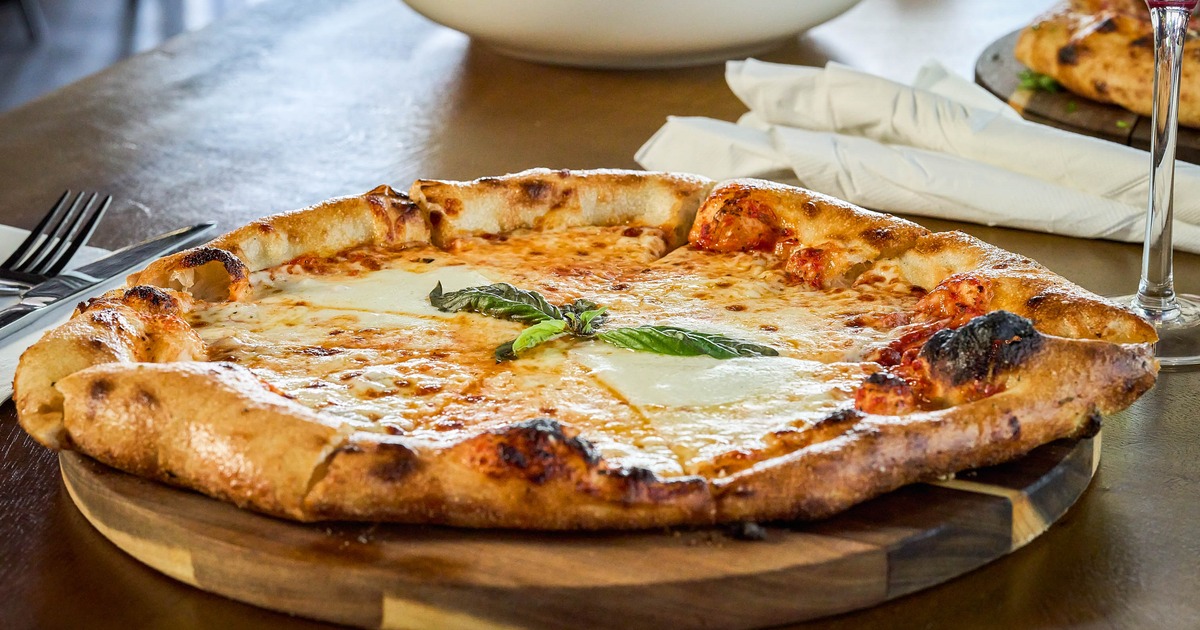 Margherita pizza on a round wooden board
