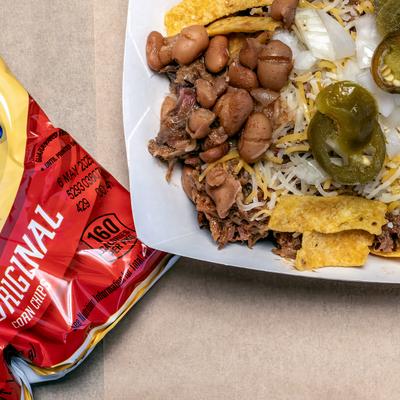 Frito pie plate and a bag of fritos  on table, top view.