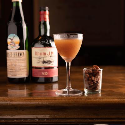 Bitter Sweet Samba cocktail next to a  glass shot with pecans