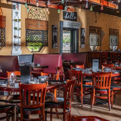 Dining area with set tables, wall art, booths, and string lights.