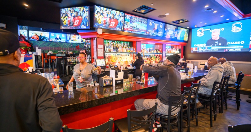 Interior, bar, bar stools, bartender, guests, tv screens