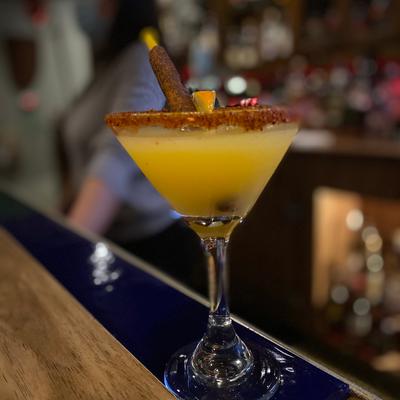 Yellow cocktail on a bar.