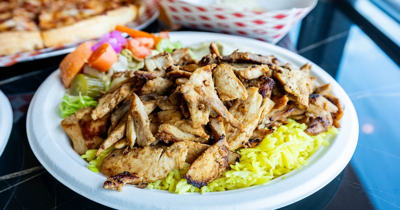 Chicken shawarma with yellow rice, vegetables, and garlic sauce