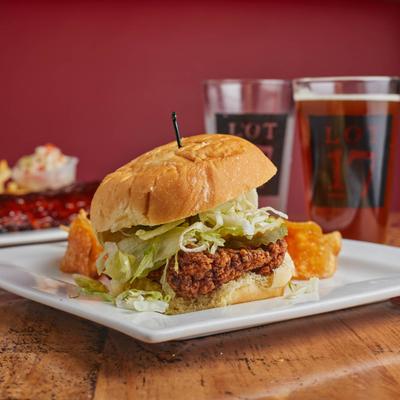 Nashville Hot Chicken sandwich, with shredded lettuce, pickles, and a side of chips.