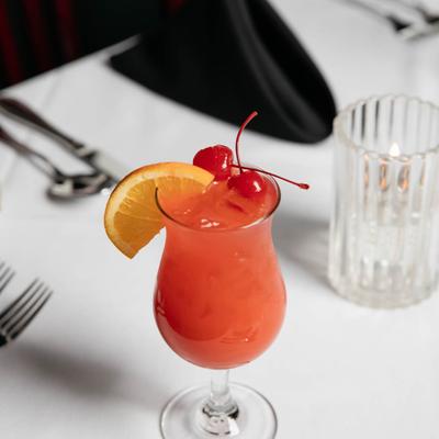 Hurricane cocktail served on table with tableware