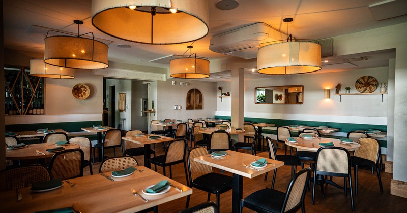 Interior, dining area, wooden top tables with chairs, banquette bench with tables in the back