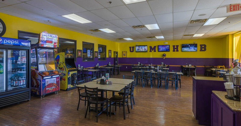 Inside, dining tables, arcade games, TVs on the wall