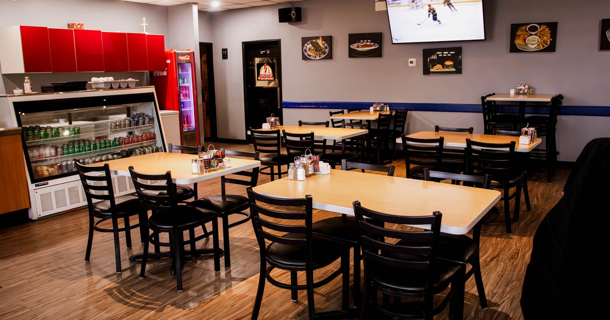 Interior, dining area, tables for four, canned drinks display case, TV on the wall