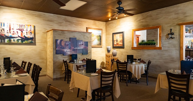 Interior, seating area, tables with chairs, ready for guests, various paintings as a decoration