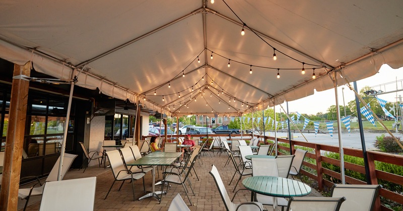 Exterior,  a tent above the tables and chairs