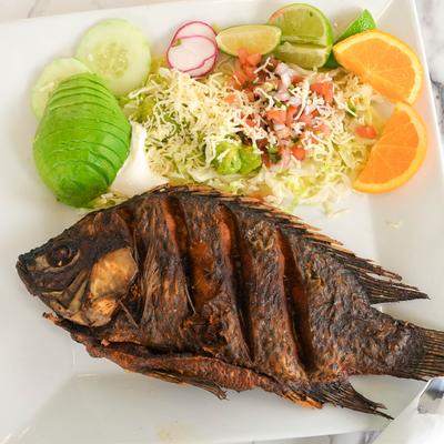 Fried whole fish served with salad.
