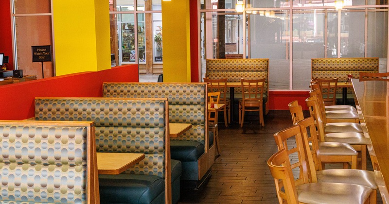 Interior - colorful booths and counter seating, featuring red and yellow walls.