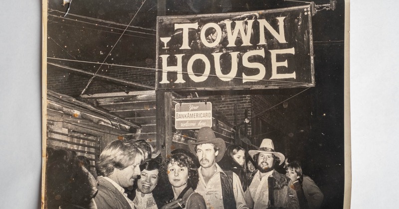 Vintage photo of people gathered under a Town House sign at night